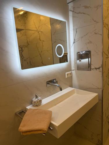a bathroom sink with a mirror and a towel at Alea in Tuttlingen