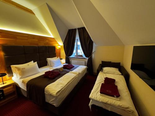 a hotel room with two beds and a window at Romantik Spa Hotel in Yaremche