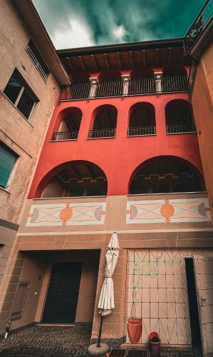 a red building with a woman standing outside of it at Casa Vacanze al Lago P1 in Monasterolo del Castello