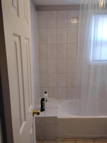a white bathroom with a tub and a shower at Grove 125 in Irvington