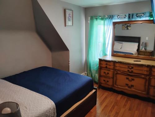 a bedroom with a bed and a dresser with a mirror at Grove 125 in Irvington