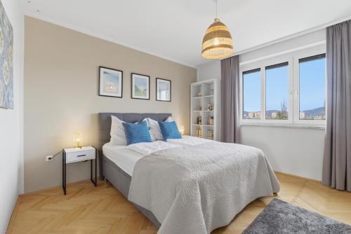 a bedroom with a large bed with blue pillows at Zentral und Ruhig am Park - 2BR - gratis Parken - 2 Balkone in Graz