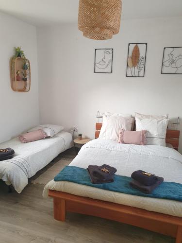two beds in a room with towels on them at Coquette Maison, Côté Château à Mutzig en Alsace in Mutzig