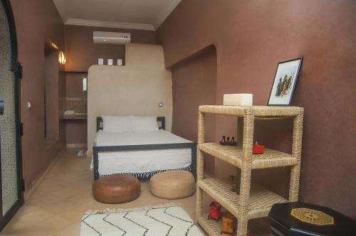 a small bedroom with a bed and a shelf at Riad Hadda in Marrakesh
