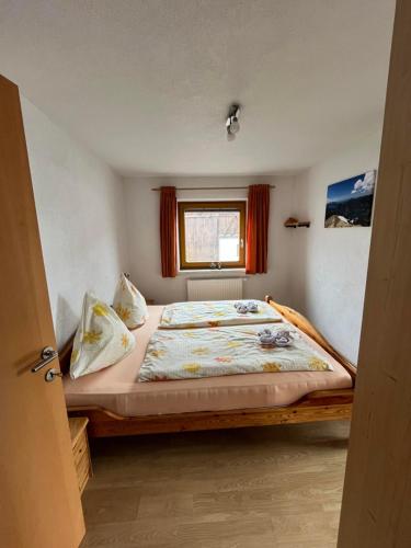a bedroom with a large bed with a window at Haus Alpenblick in Bichlbach