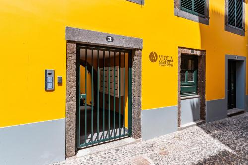 a yellow building with a gate in front of it at FLH Viola Market Flats in Funchal