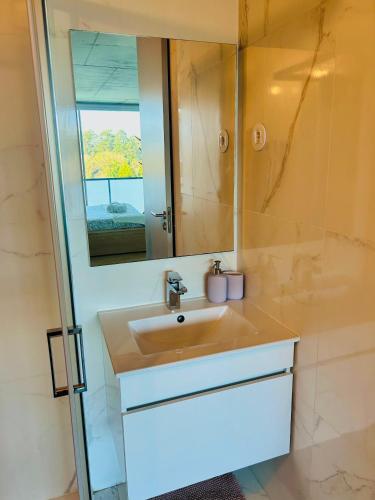 a bathroom with a sink and a mirror at Skyline Heaven - Fantastic View - Pool - Garage in Vila Nova de Gaia