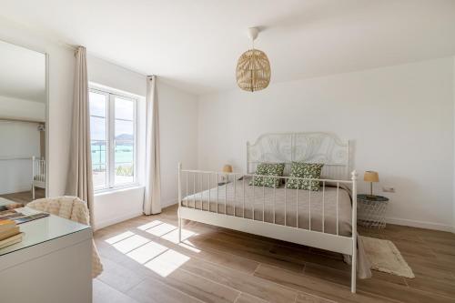 a white bedroom with a bed and a window at Fuerte Roche 1 in Tuineje
