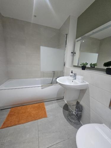 a bathroom with a sink and a tub and a toilet at The Brown Rest House in Gravesend