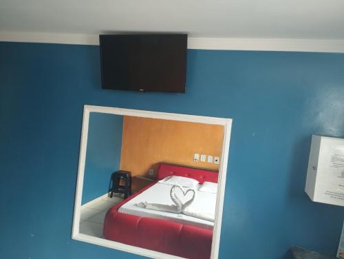 a mirror in a room with a bed with two hearts at Motel pousada Zafira in Salvador