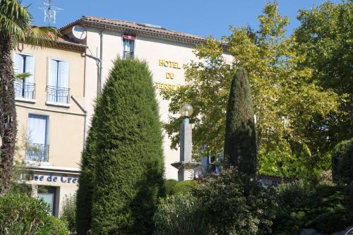 a building with a lot of trees in front of it at Logis hôtel du terreau in Manosque