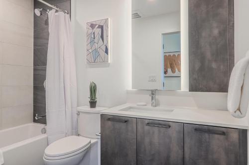 a white bathroom with a toilet and a sink at Landing Stunning 2BD Pool Courtyard in Washington