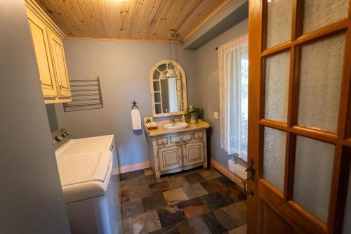 a bathroom with a sink and a mirror at Camping de la Rivière Nicolet in Wotton