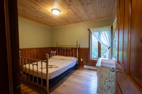 a bedroom with a bed and a window at Camping de la Rivière Nicolet in Wotton