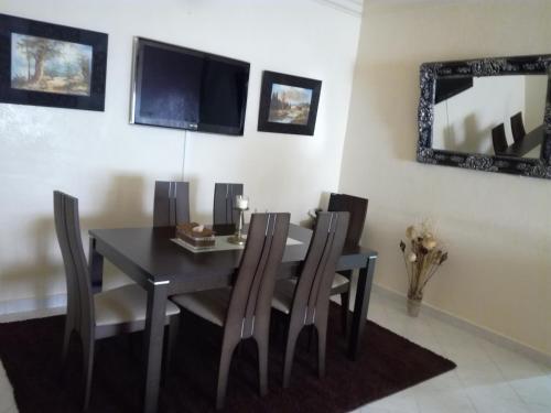 una sala da pranzo con tavolo, sedie e uno specchio di Kim Apartment a Marrakech
