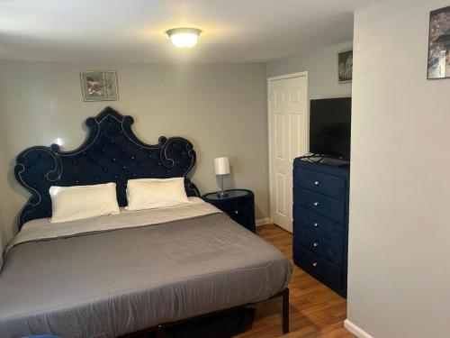 a bedroom with a bed and a dresser with a television at Grove 3- King Bed with Private Bathroom in Irvington