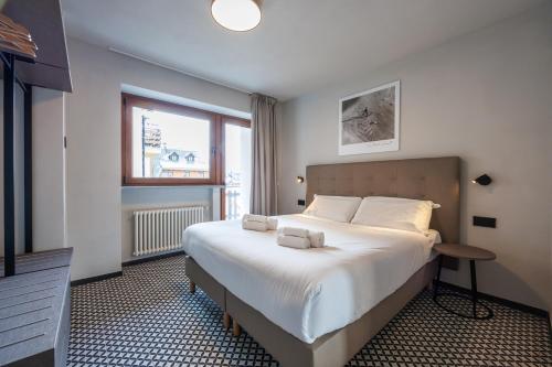 a bedroom with a large bed and a window at Central Guest in Sauze dʼOulx