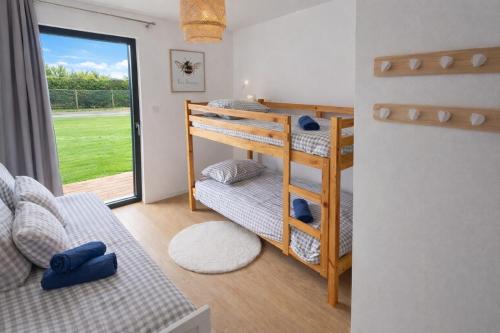 a room with a bunk bed and a couch at Villa Armor Vue mer et Spa in Carantec