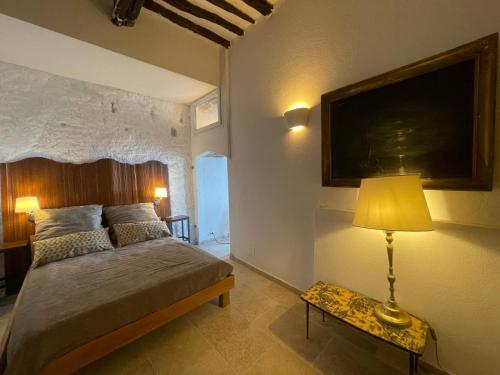 a bedroom with a bed and a table with a lamp at Fleur de Falaise in Bonifacio