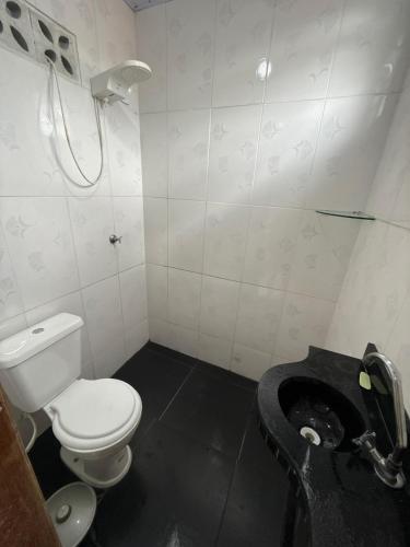 a bathroom with a toilet and a shower in it at Casa disponível para o carnaval in Belém