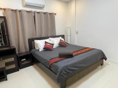 a bedroom with a bed with pillows and a window at The Living - Holiday Home Phayao in Phayao
