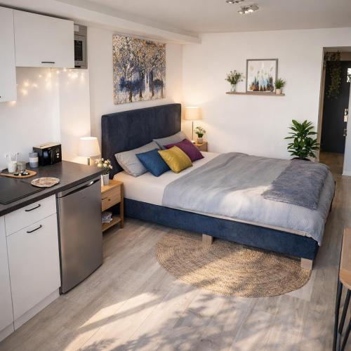 a bedroom with a large bed and a kitchen at Abby Apartment Koper in Koper