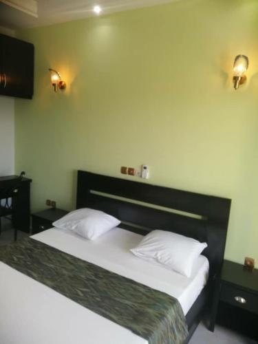 a bedroom with a large bed with white pillows at Résidence Inspire in Douala