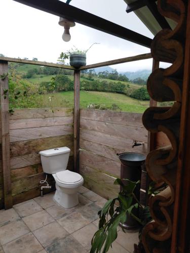 a bathroom with a toilet and a view of a field at Refugio rural MITA in Zipacón