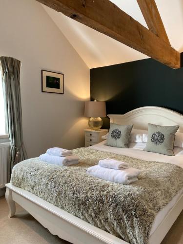 a bedroom with a large bed with two pillows at The Brosterfield Suite - Brosterfield Farm in Bakewell
