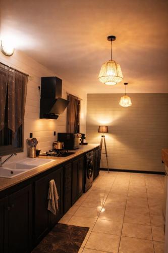 a kitchen with a counter and a sink and lights at Là-Haut in Le Tampon