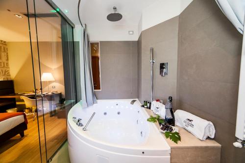 a large bathroom with a tub and a shower at Dal Moro Gallery Hotel in Assisi