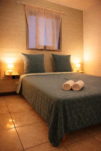 a bedroom with a bed with two towels on it at Là-Haut in Le Tampon