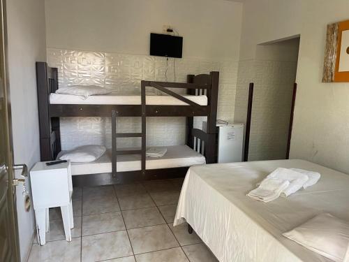 a room with two bunk beds and a bed at Pousada Rozam in Olímpia