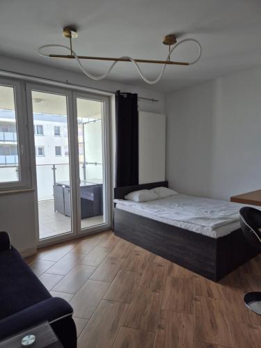 a bedroom with a large bed and a balcony at Apartament Golden Flight in Warsaw
