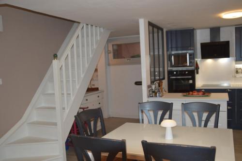 une cuisine et une salle à manger avec une table et un escalier dans l'établissement maison collioure, à Collioure