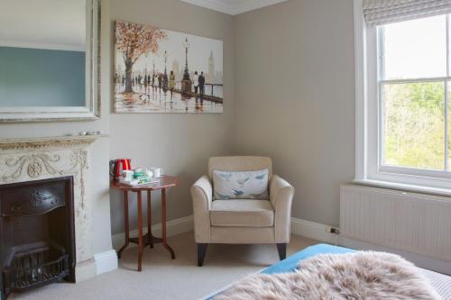 a bedroom with a chair and a fireplace at Balcarres, Rodborough Avenue in Stroud