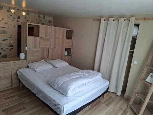 a bedroom with a large bed with white sheets at Gîte de Fond Carle in Miribel-Lanchâtre