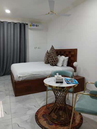 a bedroom with a bed and a table and a chair at First HR Hotel in Prampram