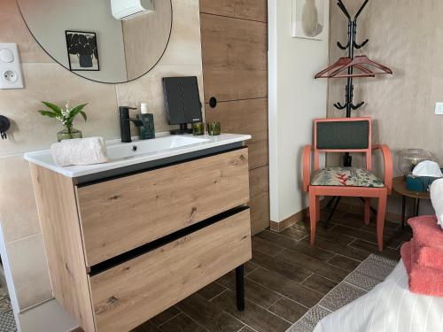 a bathroom with a sink and a mirror at À l ombre des chênes in Moissac