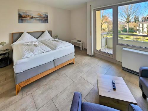 a bedroom with a bed and a large window at Hotel Schachener Hof in Lindau
