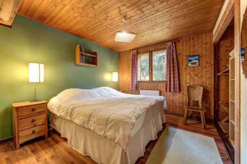 a bedroom with a bed and a chair in a room at Chalet Les Frenes in Chamonix