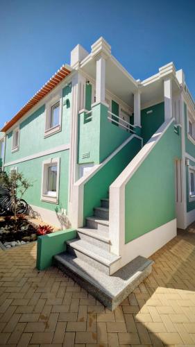 a green building with stairs in front of it at Casa do Castelo in Gafanha da Nazaré
