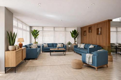 a living room with blue couches and a table at Hotel Simos in Mitika