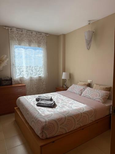 a bedroom with a large bed with a window at Apartamento MARINA PLAYA, primera linea de mar in Blanes