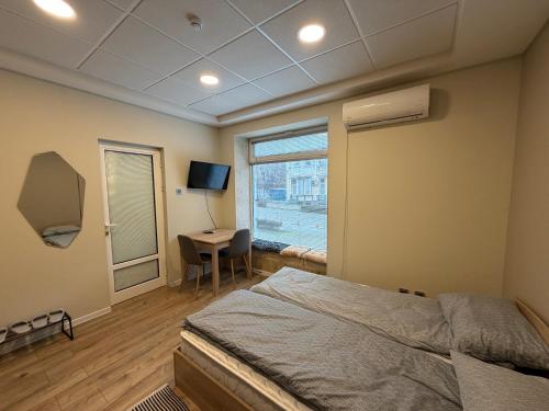 a bedroom with a bed and a desk and a window at Nõma studio in Varna City