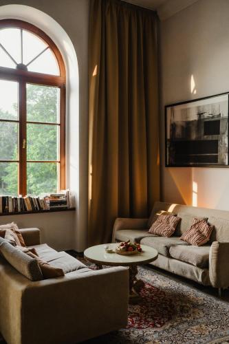 a living room with two couches and a table at Folwark Wielka Wieś in Główczyce