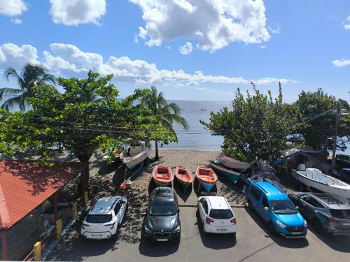 a group of cars parked on a beach next to the water at STUDIO PIEDS DANS L EAU A SCHOELCHER in Schœlcher