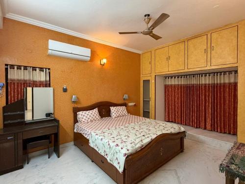 a bedroom with a bed and a dresser and a television at Naidu Villa in Secunderabad