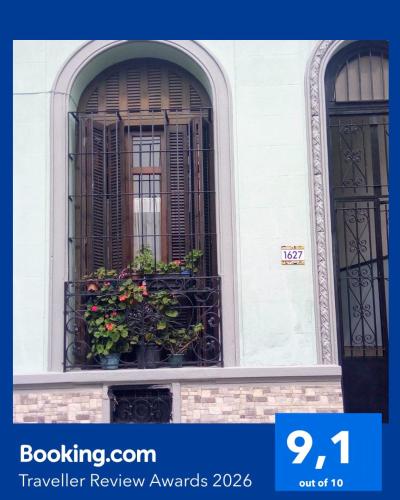 a window with a balcony with flowers in it at Tu casa en Montevideo in Montevideo