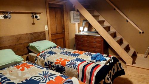 a room with two beds and a stair case at Chez Théo in Trois-Ponts